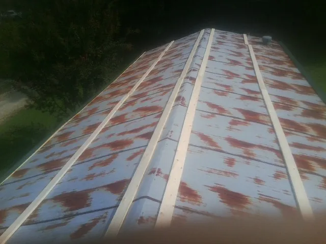 Rusted metal roof panels with new wood purlins before replacement — Storm Damage Roof Repair in Rives Junction by Roofing Brothers